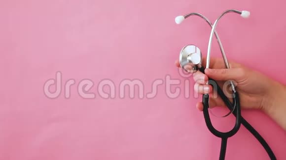 简约简约设计女性手持医疗设备听诊器或音域镜隔离在时髦的淡粉色视频的预览图