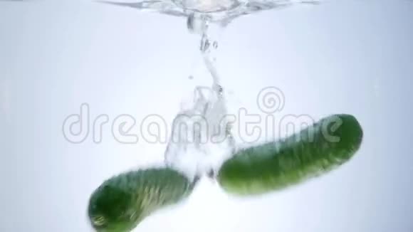 绿黄瓜滴在白色背景下分离的水中视频的预览图