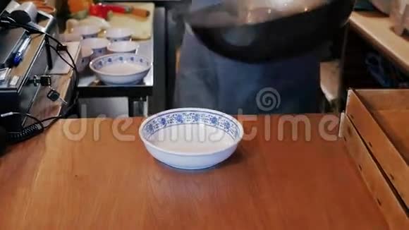 厨师把蔬菜和肉的中国面条放在碗里视频的预览图