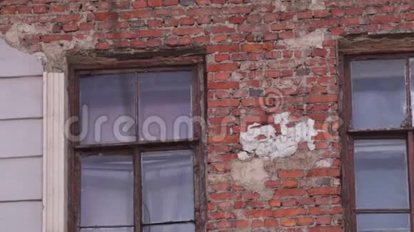旧房子的正面有砖墙和几扇窗户在白天视频的预览图