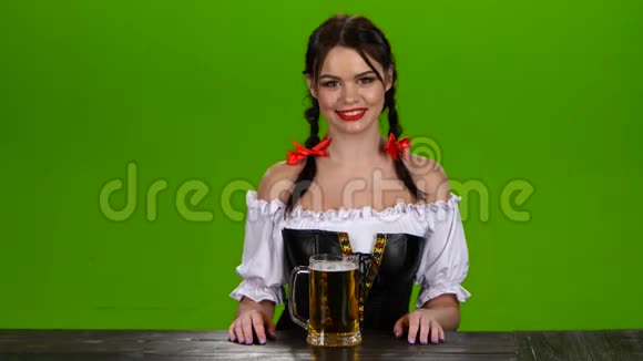穿着巴伐利亚服装的女孩微笑着竖起大拇指绿色屏幕视频的预览图