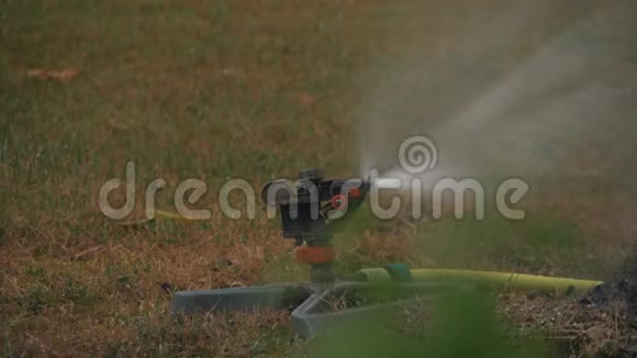 割草机在绿草上喷水草坪灌溉系统视频的预览图