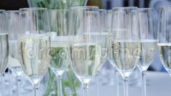 一排装满香槟的酒杯排成一排准备上桌视频的预览图