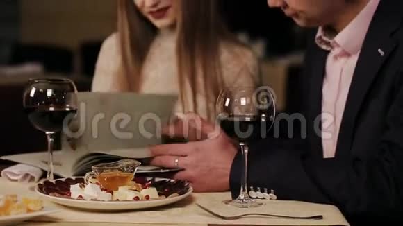 可爱的一对夫妇从餐厅的菜单上挑选一些特色菜视频的预览图