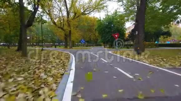 秋天公园骑自行车的人的路标空中镜头视频的预览图