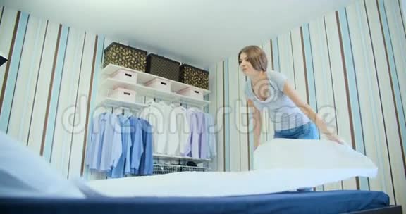 年轻的家庭主妇整理床铺视频的预览图