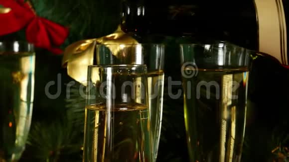 平安夜把香槟倒在玻璃杯上背景上的圣诞树和蜡烛视频的预览图
