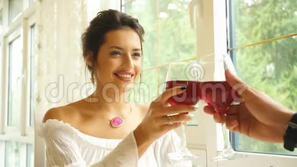 两个人用酒杯敬酒年轻夫妇在餐馆喝红酒视频的预览图