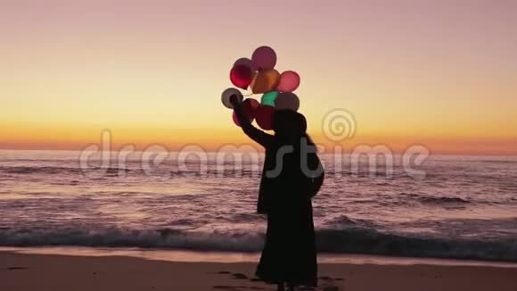带着气球在沙滩上散步的女人视频的预览图
