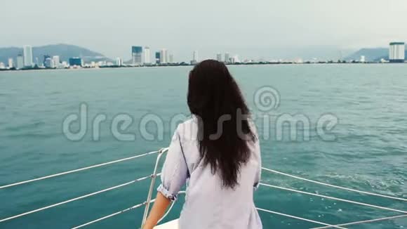 年轻女子望着大海在游艇上享受游船视频的预览图