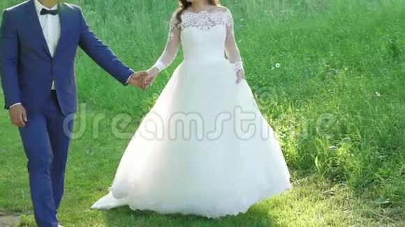 神奇的新娘对她英俊的新郎摆姿势散步和接吻慢慢地视频的预览图