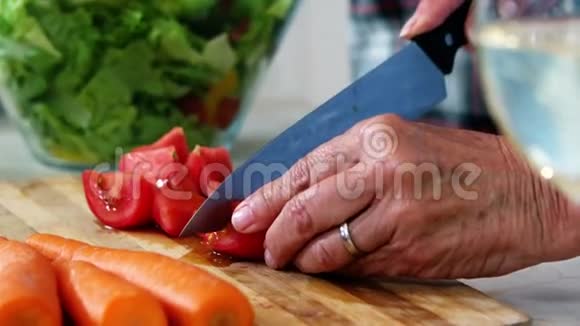 高级妇女准备蔬菜沙拉的手视频的预览图