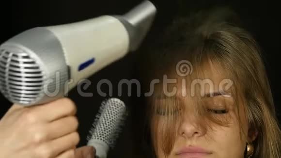 头发吹干美容美发店用吹风机烘干客户头发慢动作视频的预览图