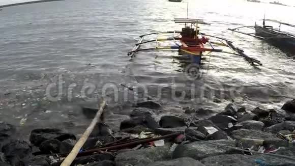 黄昏日落时分渔船停泊在海边剪影视频的预览图