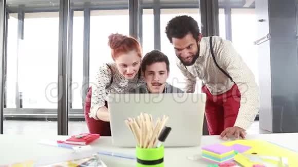 男性广告主管与同事讨论笔记本电脑的新想法视频的预览图
