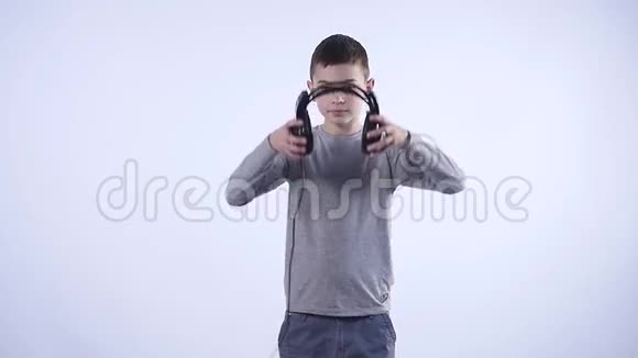 带着耳机的快乐少年被隔离在白色背景上视频的预览图