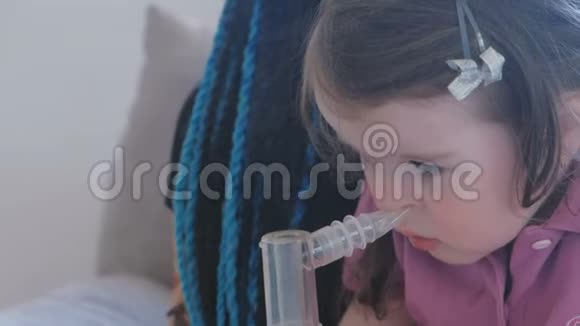 小可爱的女孩和她妈妈一起通过吸入面罩吸入使用雾化器和吸入器进行治疗视频的预览图