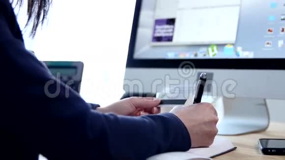 在家里或办公室的办公桌上把一只手写在议程上的女人紧紧地视频的预览图