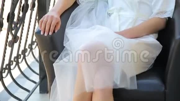 穿着睡衣坐在阳台上的可爱新娘的画像视频的预览图