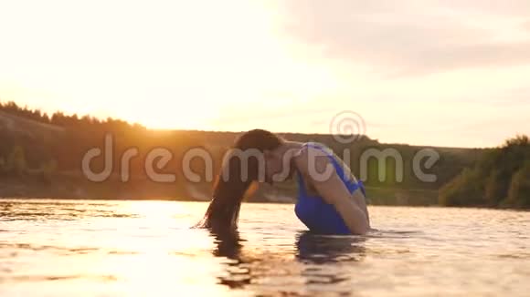 在热带小岛附近一个清爽的夏日傍晚嬉戏的女孩在清爽的河水中溅出长发视频的预览图