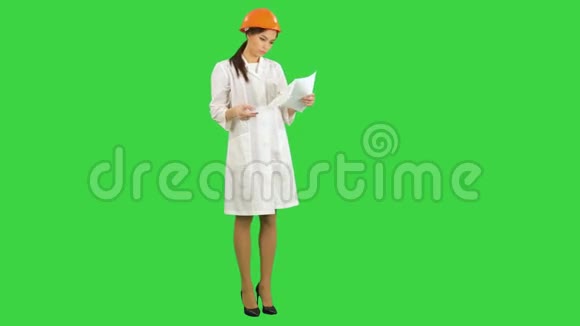 年轻的女建筑师拿着蓝图在绿色屏幕上检查建筑Chroma键视频的预览图