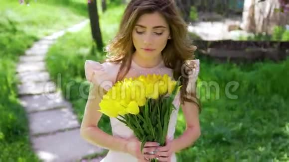 一个拿着花束的女人走在开花的树间视频的预览图