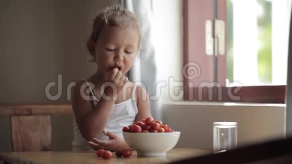可爱的小女孩吃红樱桃番茄的肖像视频的预览图