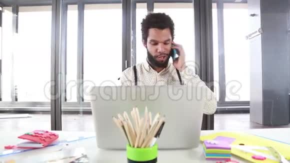 男性创意主管在笔记本电脑工作时打电话视频的预览图