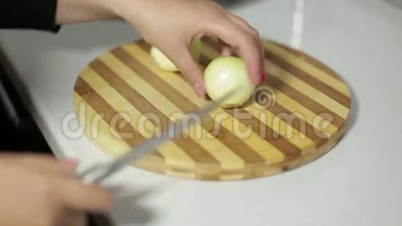 一只手拿着刀在切割板上切洋葱视频的预览图