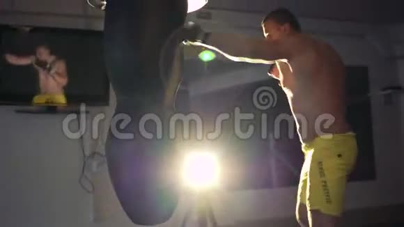 强壮的男孩在4k的笼子里用拳击袋做运动视频的预览图