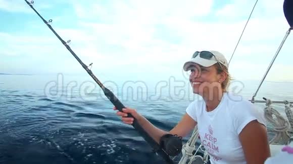 女子在海上帆船上用鱼竿捕鱼视频的预览图