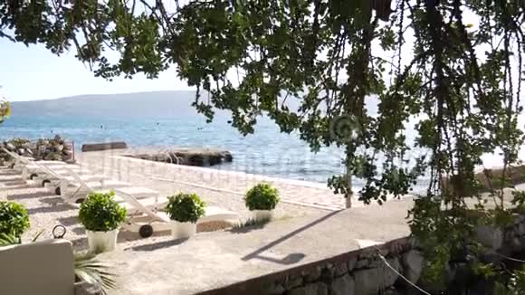 蒂瓦特海滩上的白色塑料日光浴床视频的预览图