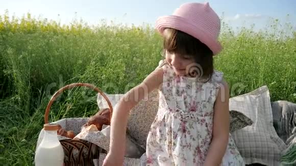 鲜花草地上可爱的女孩带着篮子去野餐巴拿马的女孩子带着面包去大自然周末野餐视频的预览图
