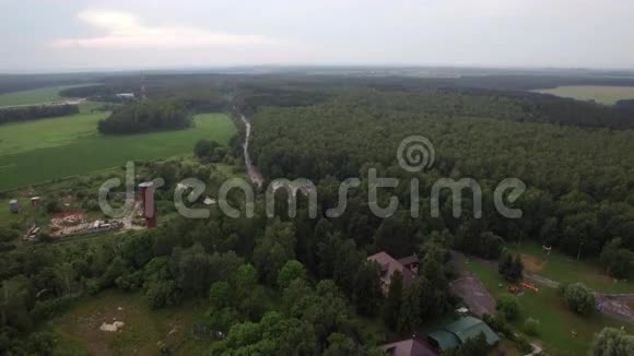 莫斯科卢基诺上空的空中飞行风景如画的绿色森林和田野乡村建筑和视频的预览图