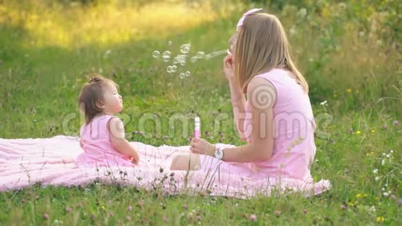 妈妈和女儿正坐在草坪上视频的预览图