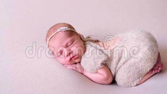 可爱的女婴躺在床上穿着羊毛视频的预览图