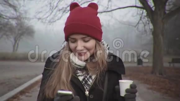 戴着红帽子的女人看着电话微笑着视频的预览图