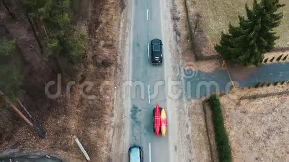 几辆车顶架上有皮划艇的汽车在林间公路上行驶视频的预览图