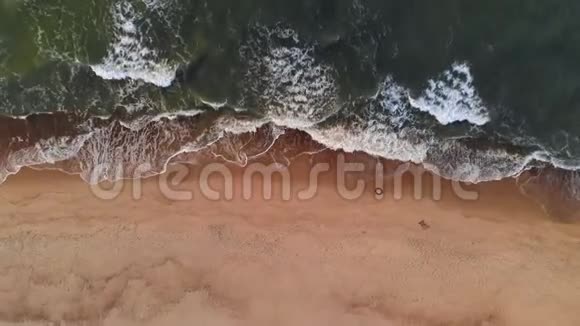 鸟瞰日落时热带海滩的一段视频显示傍晚的空中拍摄的绿色泡沫海浪拍打的画面视频的预览图