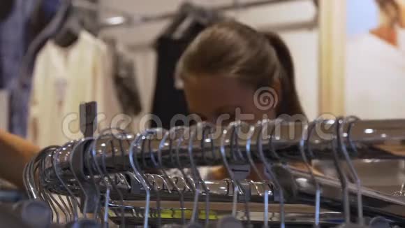 年轻女子选择商店里的衣服视频的预览图