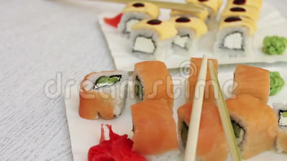 新鲜美味的寿司里面有三文鱼生姜奶酪芥末和白盘子上的木棍视频的预览图