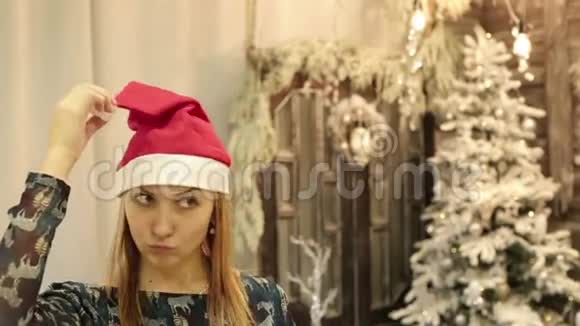 一个漂亮的年轻女人正在试穿圣诞老人的帽子视频的预览图