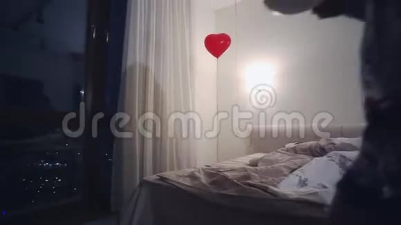 穿着睡衣的年轻女子带着一杯茶来到卧室的全景窗口气球漆黑的夜晚视频的预览图