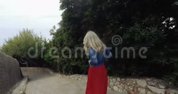 穿红裙子的女孩下楼去海滩视频的预览图