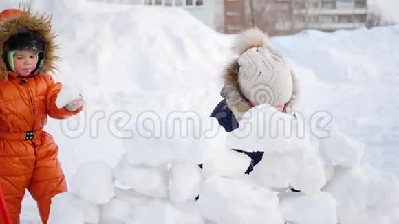 孩子们在冬天在户外玩耍孩子筑起一堵雪石墙视频的预览图