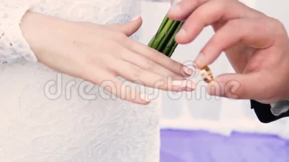 结婚典礼上新郎把金戒指戴在新娘手指上视频的预览图