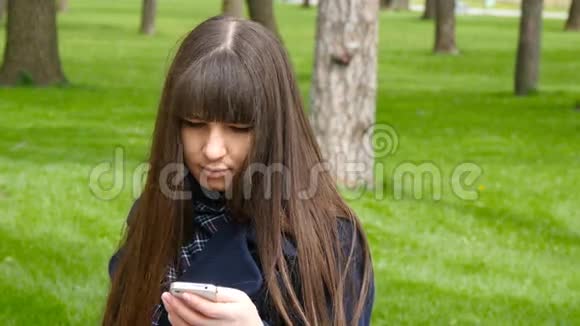 美丽的女人在公园户外使用手机细节年轻迷人的快乐女孩在城市里放松视频的预览图