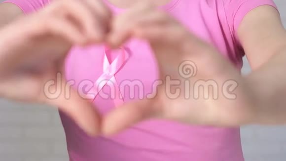女性显示心脏标志构成乳腺癌意识丝带乳腺癌意识概念视频的预览图