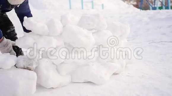冬天孩子们在户外玩耍孩子筑起一堵雪石墙视频的预览图
