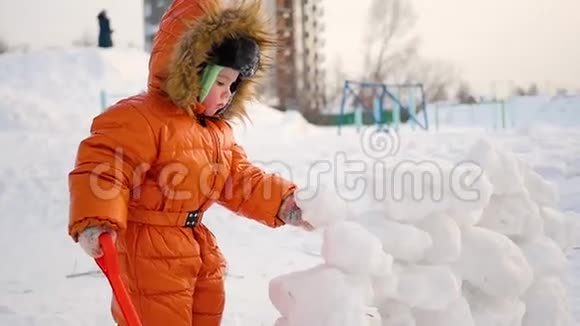 冬天孩子们在户外玩耍孩子筑起一堵雪石墙视频的预览图